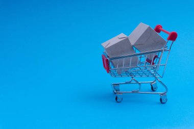 Alışveriş sepeti ve mavi arka plan, iş ve alışveriş kavramı kutu. Seçici odak