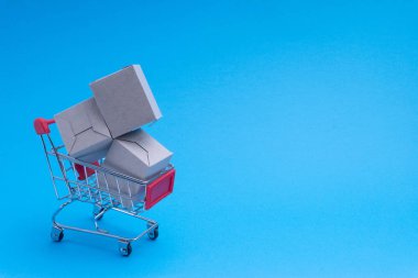 Alışveriş sepeti ve mavi arka plan, iş ve alışveriş kavramı kutu. Seçici odak