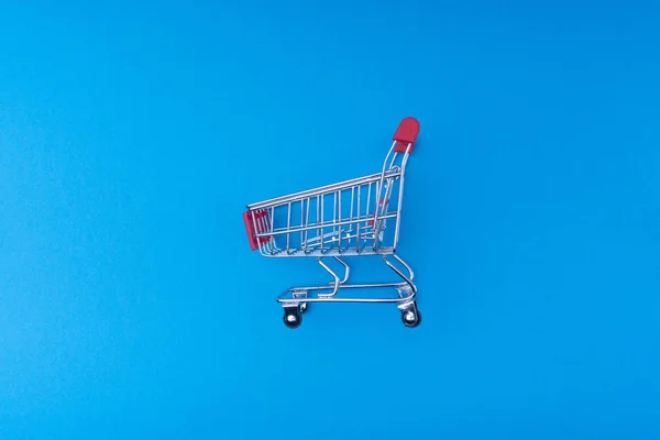 Shopping cart on blue background, business and shopping concept. Selective focus
