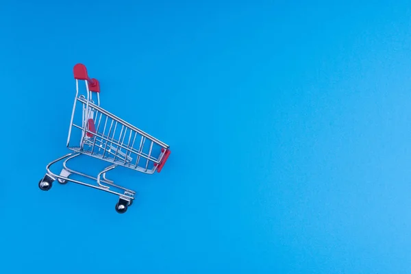 Shopping cart on blue background, business and shopping concept. Selective focus