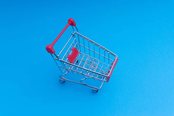 Shopping cart on blue background, business and shopping concept. Selective focus