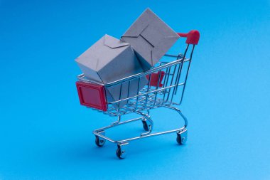 Alışveriş sepeti ve mavi arka plan, iş ve alışveriş kavramı kutu. Seçici odak