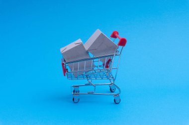 Alışveriş sepeti ve mavi arka plan, iş ve alışveriş kavramı kutu. Seçici odak