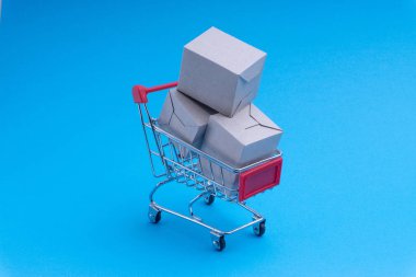 Alışveriş sepeti ve mavi arka plan, iş ve alışveriş kavramı kutu. Seçici odak