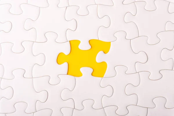 White jigsaw puzzle and missing pieces with selective focus and crop fragment