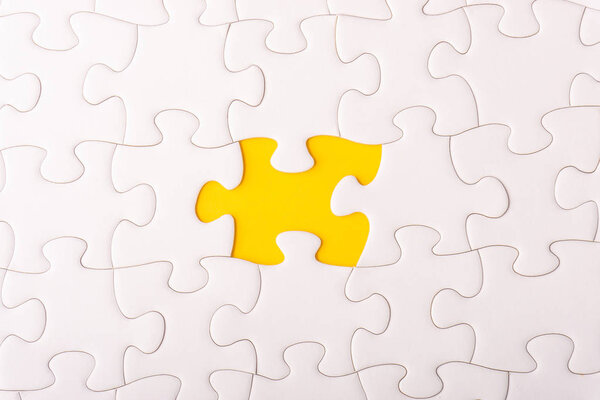 White jigsaw puzzle and missing pieces with selective focus and crop fragment