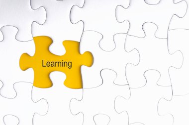 Beyaz jigsaw puzzle ve eksik parçalar ile kelime öğrenme seçici odak ve kırpma parçası