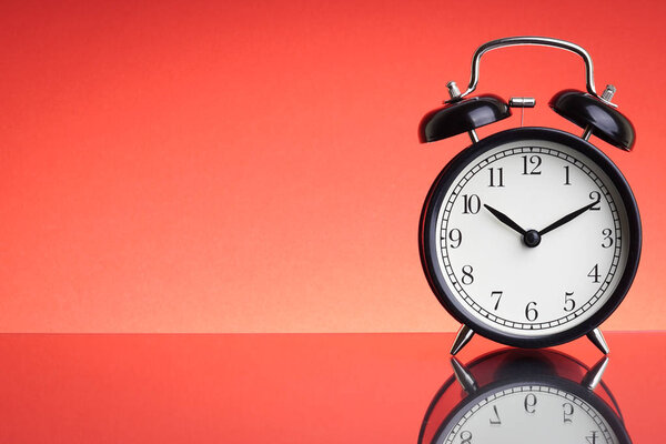 Alarm Clock on red background with selective focus and crop fragment. Business and Copy space concept