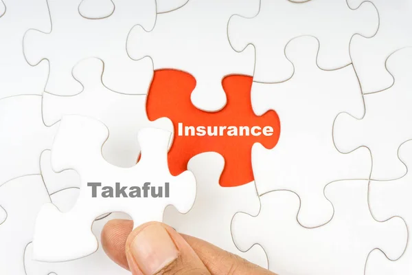 Kelime Takaful sigorta ile bilmecenin el tutan parça. Seçici odak
