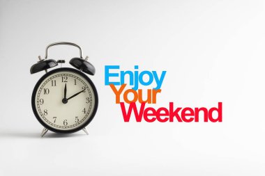 ENJOY YOUR WEEKEND inscription written and alarm clock on white background. Business and motivation concept clipart