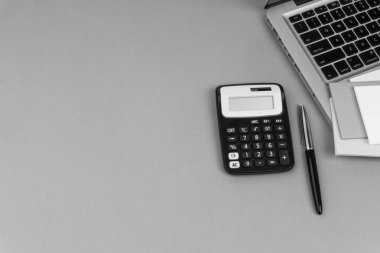 Ofis masa masasına bakın. Çalışma alanı ile hesap makinesi, siyah kalem, dizüstü siyah ve beyaz arka plan kavramı. İş finansmanı, eğitim teknolojisi ve metin konsepti için Copy Space