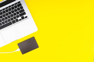 Laptop klavye, depolama sürücü veya sabit disk seçici odak, kırpma parçası, iş, yedekleme, Sarı zemin üzerine kopyalama alanı kavramı.