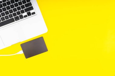 Laptop klavye, depolama sürücü veya sabit disk seçici odak, kırpma parçası, iş, yedekleme, Sarı zemin üzerine kopyalama alanı kavramı.