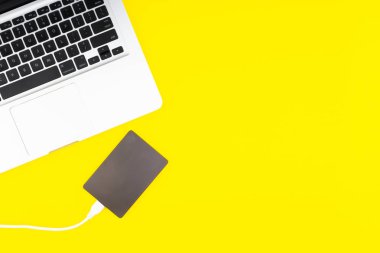 Laptop klavye, depolama sürücü veya sabit disk seçici odak, kırpma parçası, iş, yedekleme, Sarı zemin üzerine kopyalama alanı kavramı.