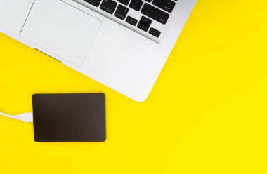 Laptop klavye, depolama sürücü veya sabit disk seçici odak, kırpma parçası, iş, yedekleme, Sarı zemin üzerine kopyalama alanı kavramı.