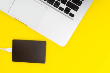 Laptop klavye, depolama sürücü veya sabit disk seçici odak, kırpma parçası, iş, yedekleme, Sarı zemin üzerine kopyalama alanı kavramı.