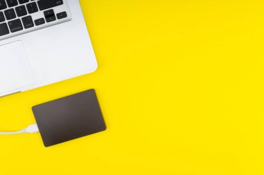 Laptop klavye, depolama sürücü veya sabit disk seçici odak, kırpma parçası, iş, yedekleme, Sarı zemin üzerine kopyalama alanı kavramı.