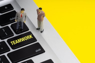 Ekip çalışması kitabe yazılmış sözcükler, dizüstü bilgisayar, sabit disk ve işadamı minyatür. İş ve teknoloji kavramı