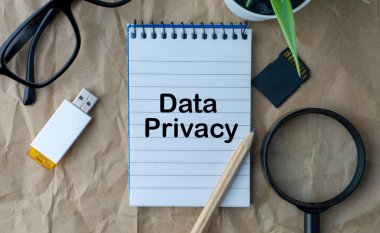 Not defteri, çiçek vazo, gözlük, depolama kartı, kalem, büyüteç ve ahşap kağıt arka plan üzerinde kelime Veri Gizlilik. İş, eğitim ve kopyalama alanı kavramı