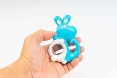 Eller beyaz arka planda çıngıraklı oyuncak veya bebek oyuncak tutun. Seçici odaklama