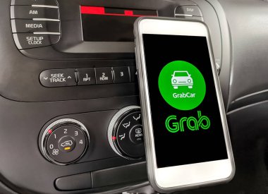 Kuala Lumpur: 11 Nisan 2019 - Gösterge panelinde Grab uygulaması olan akıllı telefonu kullanan araç sürücüsü. Seçici odaklama