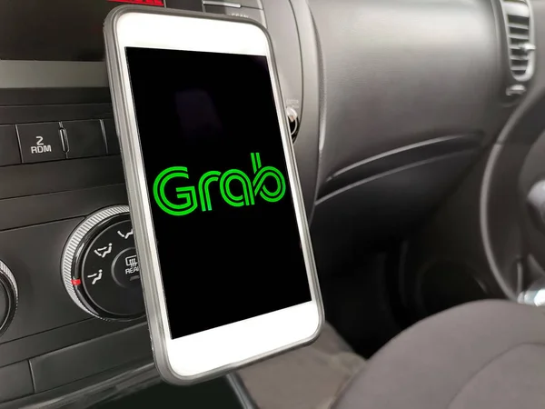 Kuala Lumpur: 11 Nisan 2019 - Gösterge panelinde Grab uygulaması olan akıllı telefonu kullanan araç sürücüsü. Seçici odaklama
