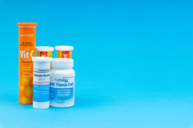 Multivitamin tabletler ve Mavi arka plan üzerinde C vitamini konteyner closeup. Seçici odaklama ve kırpma parçası