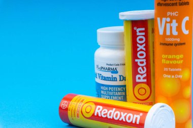 Multivitamin tabletler ve Mavi arka plan üzerinde C vitamini konteyner closeup. Seçici odaklama ve kırpma parçası