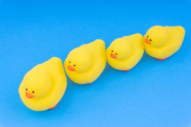 Yellow rubber duck on blue background. Selective focus and copy space concept