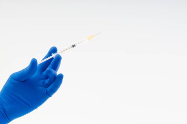 Beyaz şırıngayı tutan mavi bir eldiven verin.