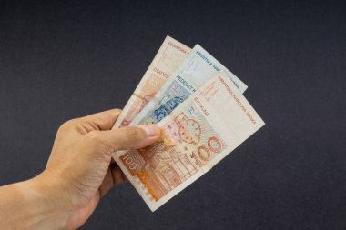 El siyah arka plan üzerinde elli Hırvat Kuna veya Sto Kuna banka notları tutan. Finansal kavram ve seçici odak