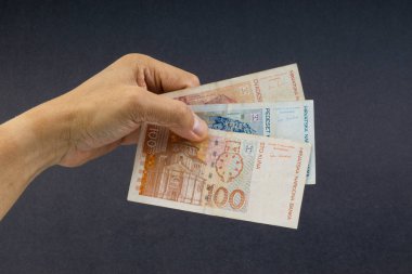 El siyah arka plan üzerinde elli Hırvat Kuna veya Sto Kuna banka notları tutan. Finansal kavram ve seçici odak