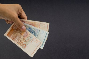 El siyah arka plan üzerinde elli Hırvat Kuna veya Sto Kuna banka notları tutan. Finansal kavram ve seçici odak