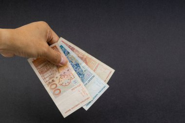 El siyah arka plan üzerinde elli Hırvat Kuna veya Sto Kuna banka notları tutan. Finansal kavram ve seçici odak