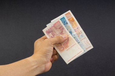 El siyah arka plan üzerinde elli Hırvat Kuna veya Sto Kuna banka notları tutan. Finansal kavram ve seçici odak