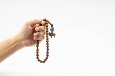 El beyaz arka plan üzerinde bir Müslüman tespih boncuk veya Tesbih tutan. Kopya alanı ve seçici odak 