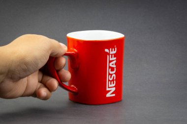 Kuala Lumpur, Malezya - 03 Temmuz 2019 : Koyu arka planda promosyon kırmızı Nescafe kupa. Seçici odaklama