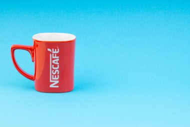 Kuala Lumpur, Malezya - 03 Temmuz 2019: Mavi arka plan üzerine promosyon kırmızı Nescafe kupa. Seçici odaklama