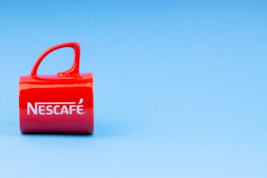 Kuala Lumpur, Malezya - 03 Temmuz 2019: Mavi arka plan üzerine promosyon kırmızı Nescafe kupa. Seçici odaklama
