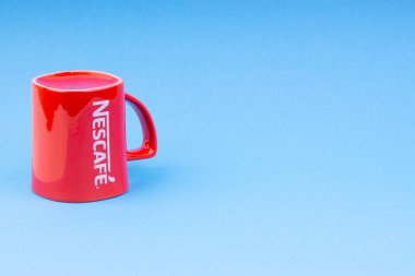 Kuala Lumpur, Malezya - 03 Temmuz 2019: Mavi arka plan üzerine promosyon kırmızı Nescafe kupa. Seçici odaklama