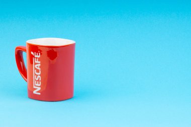Kuala Lumpur, Malezya - 03 Temmuz 2019: Mavi arka plan üzerine promosyon kırmızı Nescafe kupa. Seçici odaklama