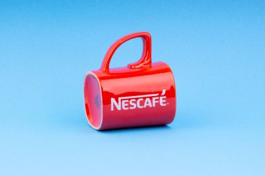 Kuala Lumpur, Malezya - 03 Temmuz 2019: Mavi arka plan üzerine promosyon kırmızı Nescafe kupa. Seçici odaklama