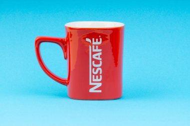 Kuala Lumpur, Malezya - 03 Temmuz 2019: Mavi arka plan üzerine promosyon kırmızı Nescafe kupa. Seçici odaklama