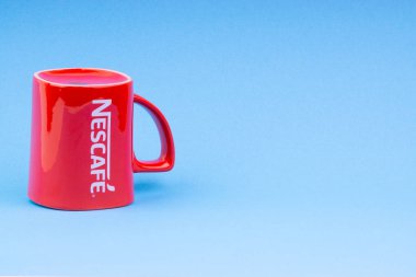 Kuala Lumpur, Malezya - 03 Temmuz 2019: Mavi arka plan üzerine promosyon kırmızı Nescafe kupa. Seçici odaklama