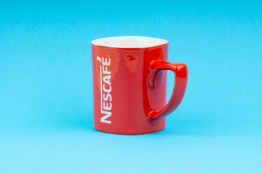 Kuala Lumpur, Malezya - 03 Temmuz 2019: Mavi arka plan üzerine promosyon kırmızı Nescafe kupa. Seçici odaklama
