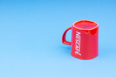 Kuala Lumpur, Malezya - 03 Temmuz 2019: Mavi arka plan üzerine promosyon kırmızı Nescafe kupa. Seçici odaklama