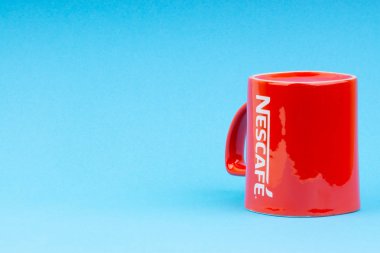 Kuala Lumpur, Malezya - 03 Temmuz 2019: Mavi arka plan üzerine promosyon kırmızı Nescafe kupa. Seçici odaklama