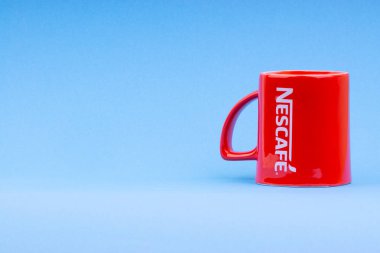 Kuala Lumpur, Malezya - 03 Temmuz 2019: Mavi arka plan üzerine promosyon kırmızı Nescafe kupa. Seçici odaklama