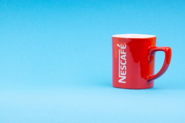 Kuala Lumpur, Malezya - 03 Temmuz 2019: Mavi arka plan üzerine promosyon kırmızı Nescafe kupa. Seçici odaklama