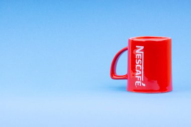 Kuala Lumpur, Malezya - 03 Temmuz 2019: Mavi arka plan üzerine promosyon kırmızı Nescafe kupa. Seçici odaklama